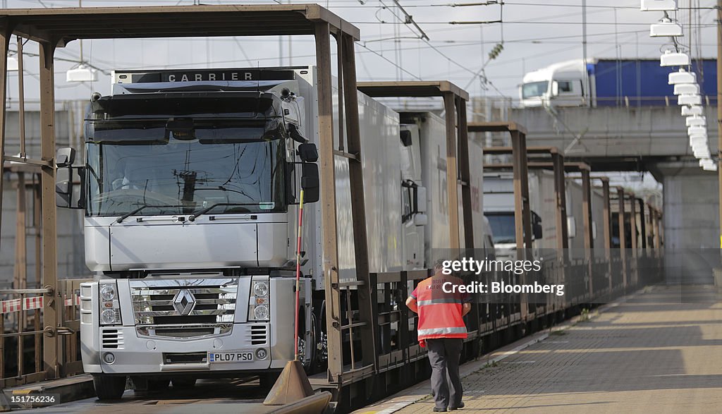 Freight Shuttle Train An employee passes trucks loaded onto Eurotunnel shuttle wagons ...