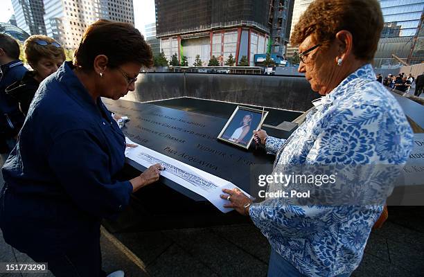 Linda Malerba and Judy Parisio who lost their neice Fances Ann Cilente make a rubbing of her name at the edge of the North Pool during observances...