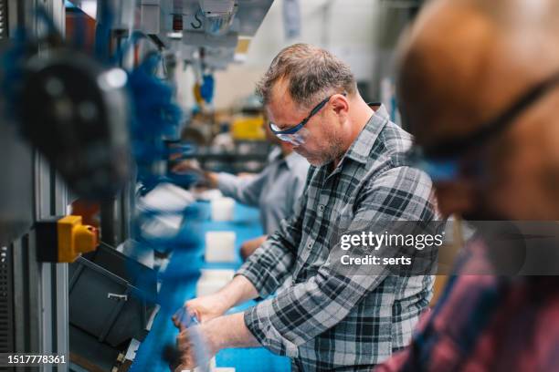 male industry employees work on production line at factory - production line worker stock pictures, royalty-free photos & images