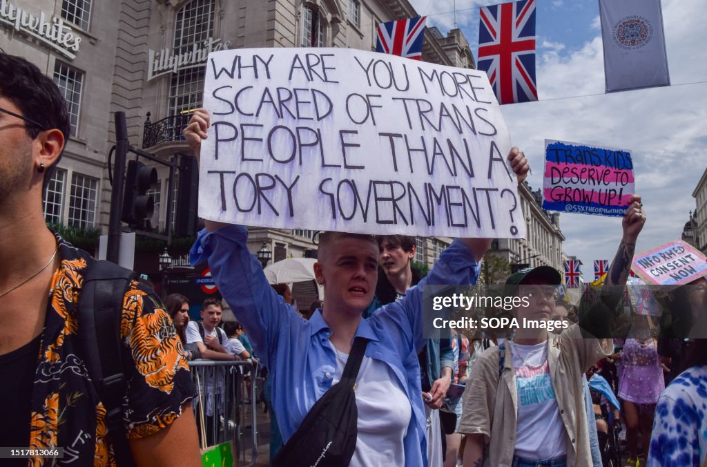 A protester holds a placard which states 'Why are you more...