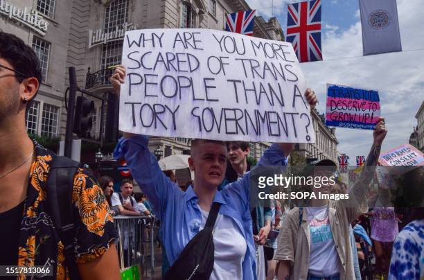 Protester holds a placard which states 'Why are you more scared of trans people than a Tory Government' during the demonstration in Piccadilly...