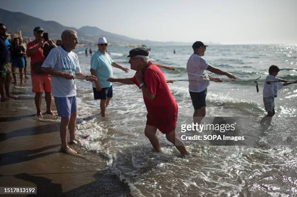 Local seen using a net to capture fish as he takes part in the 'La Tirada del Copo' exhibition at Los Boliches beach. Every year in Fuengirola,...