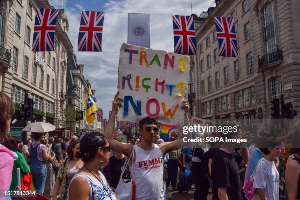 Protester holds a 'Trans rights now' placard during the demonstration in Piccadilly Circus. Thousands of people marched through central London during...