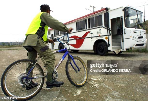 Security officer patrols the area in Guatemala City 19 May 2003. Un guardia de seguridad privada observa el 19 de mayo de 2003 un autobús estacionado...