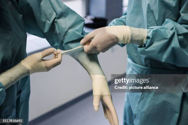 May 2023, North Rhine-Westphalia, Cologne: Pirkko Schuppan , intimate surgery doctor, puts on gloves in the operating room. Photo: Oliver Berg/dpa
