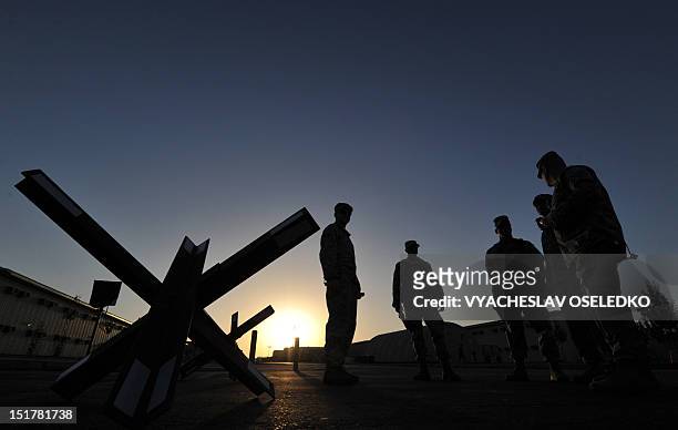 Servicemen take part in a brief ceremony in remembrance of those who perished eleven years ago in the 9/11 attacks at the US transit center in Manas...