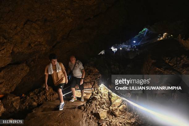 Visitors walk inside the Tham Luang Cave in Mae Sai district in the northern province of Chiang Rai on July 10 during an event to mark the five-year...