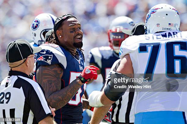 Brandon Spikes of the New England Patriots shares his thoughts with David Stewart of the Tennessee Titans during the season opener at LP Field on...