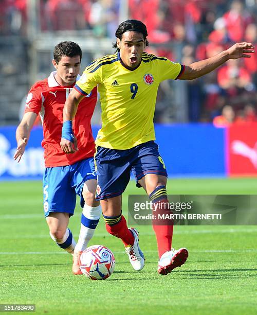 Colombian forward Radamel Falcao is marked by Chilean defender Eugenia Mena during their Brazil 2014 FIFA World Cup South American qualifier match...