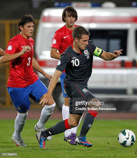 Aaron Ramsey of Wales drives the ball near Ljubomir Fejsa of Serbia during the FIFA 2014 World Cup Qualifier at stadium Karadjordje Park between...