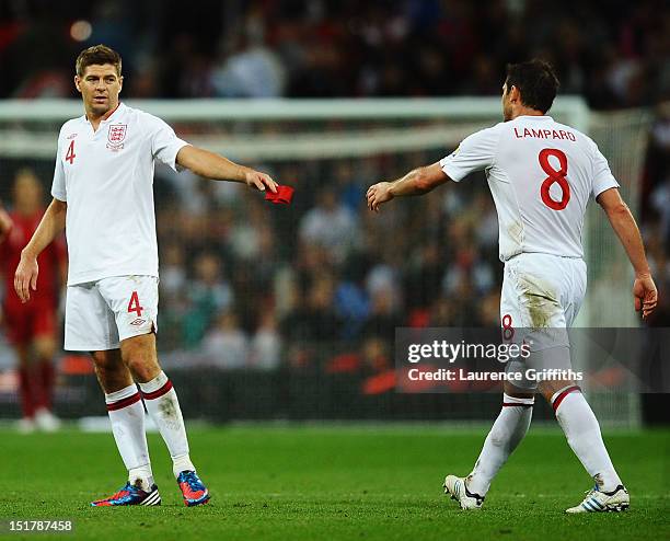 Steven Gerrard of England passes the captains armband to Frank Lampard of England after being sent off by match referee Cuneyt Cakir during the FIFA...