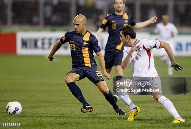 Marco Bresciano of Australia is challenged during their 2014 World Cup group B qualifying football match at King Abdullah Stadium in Amman, Jordan on...