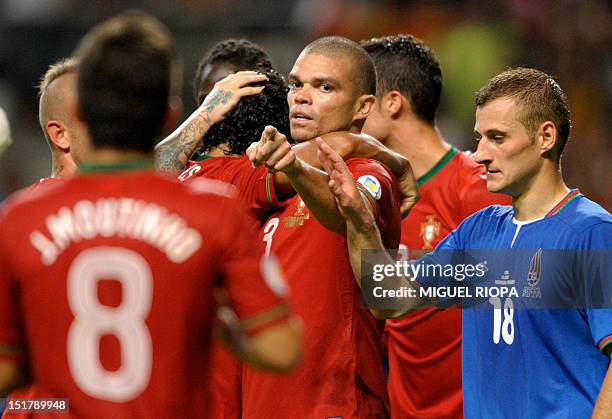 Portugal's players celebrate after scoring their third goal next to Azerbaijan's defender Maksim Medvedev during the FIFA World Cup 2014 qualifying...