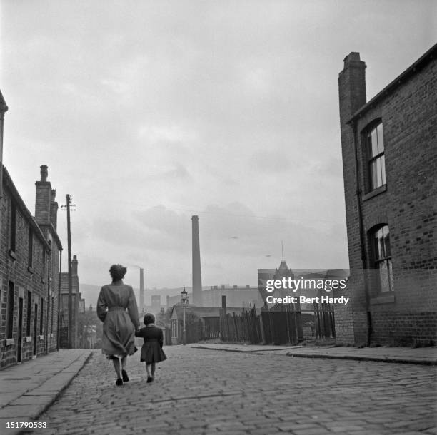 Cotton mill worker Alice Nelson sets out for work at the Lilac Mill in Shaw, Lancashire, January 1955. Original publication: Picture Post - 7474 -...