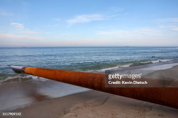 Pipe from a sand pumping barge off-shore lays across the beach as the Army Corps of Engineers continues their beach and dune replenishment project on...