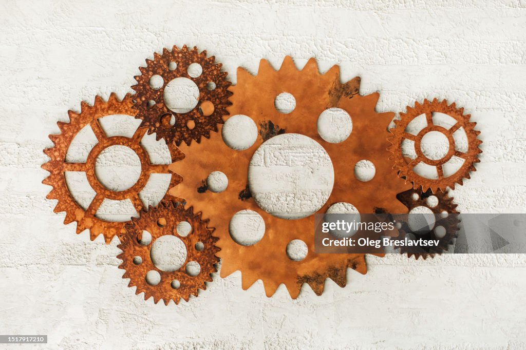 Conceptual background of metal clock mechanism or clockwork on white wall