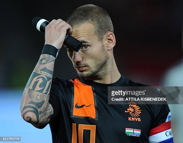 Netherland's captain Wesley Sneijder gestures as he holds a microphone prior to the World Cup 2014 qualifying football match Hungary vs The...