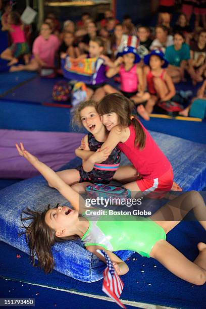 Jacquelyn Dupre-Honda of Brookline, front, Zoe Goldberg of Newton and Jasmin Dowling of Needham rejoice after the USA women's gymnastics team won...