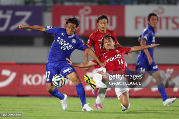 Yu Eto of Tokushima Vortis and Tadaaki Hirakawa of Urawa Red Diamonds compete for the ball during the J.League J1 match between Tokushima Vortis and...