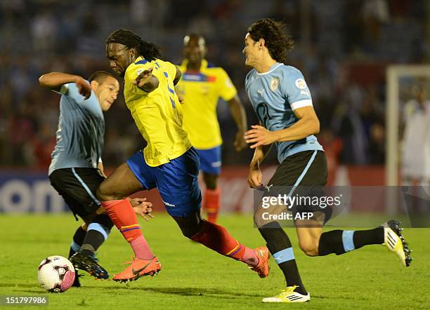 Ecuadorean forward Felipe Caicedo is marked by Uruguayan midfielder Walter Gargano and Uruguayan forward Edinson Cavani during their Brazil 2014 FIFA...