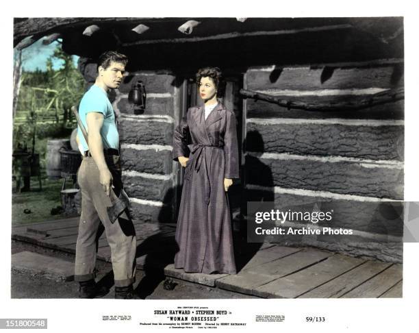 Stephen Boyd holds an axe with Susan Hayward in a scene from the film 'Woman Obsessed', 1959.