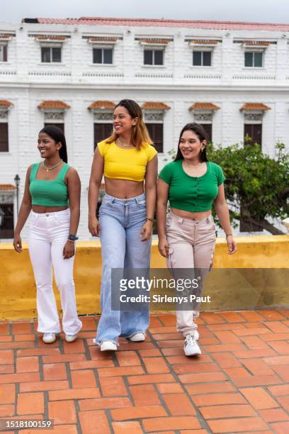 multiracial female friends walking together on a street in the city - amigos baile stockfoto's en -beelden