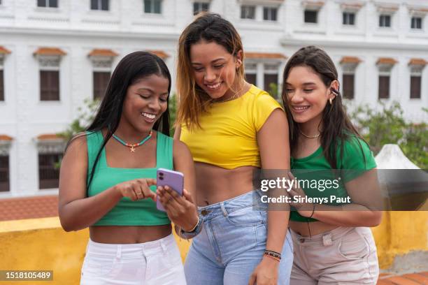 young friends looking at smartphone in park - amigos baile bildbanksfoton och bilder