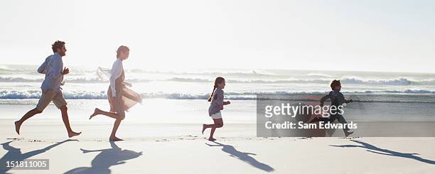 family running on sunny beach - family running stock pictures, royalty-free photos & images