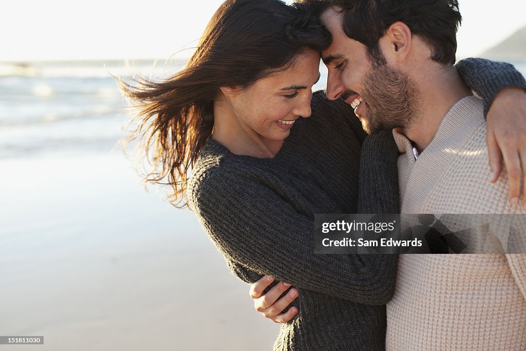 Smiling couple hugging on beach