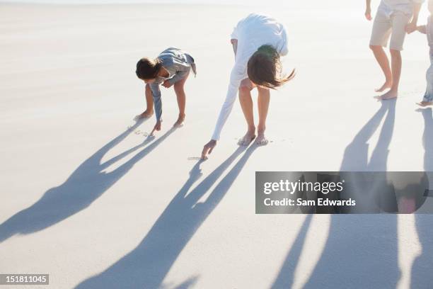 family writing in sand on beach - bending stock pictures, royalty-free photos & images
