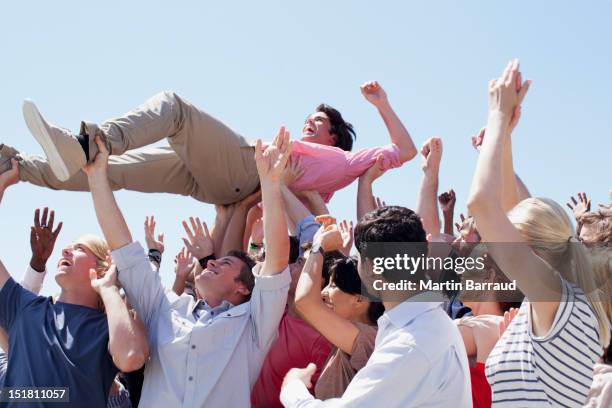 man crowd surfing - crowd carrying person stock pictures, royalty-free photos & images