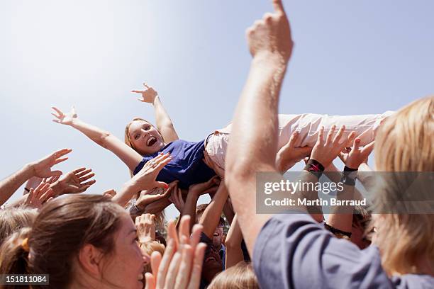 entusiasta mujer a hombros de la multitud - exhilaration fotografías e imágenes de stock