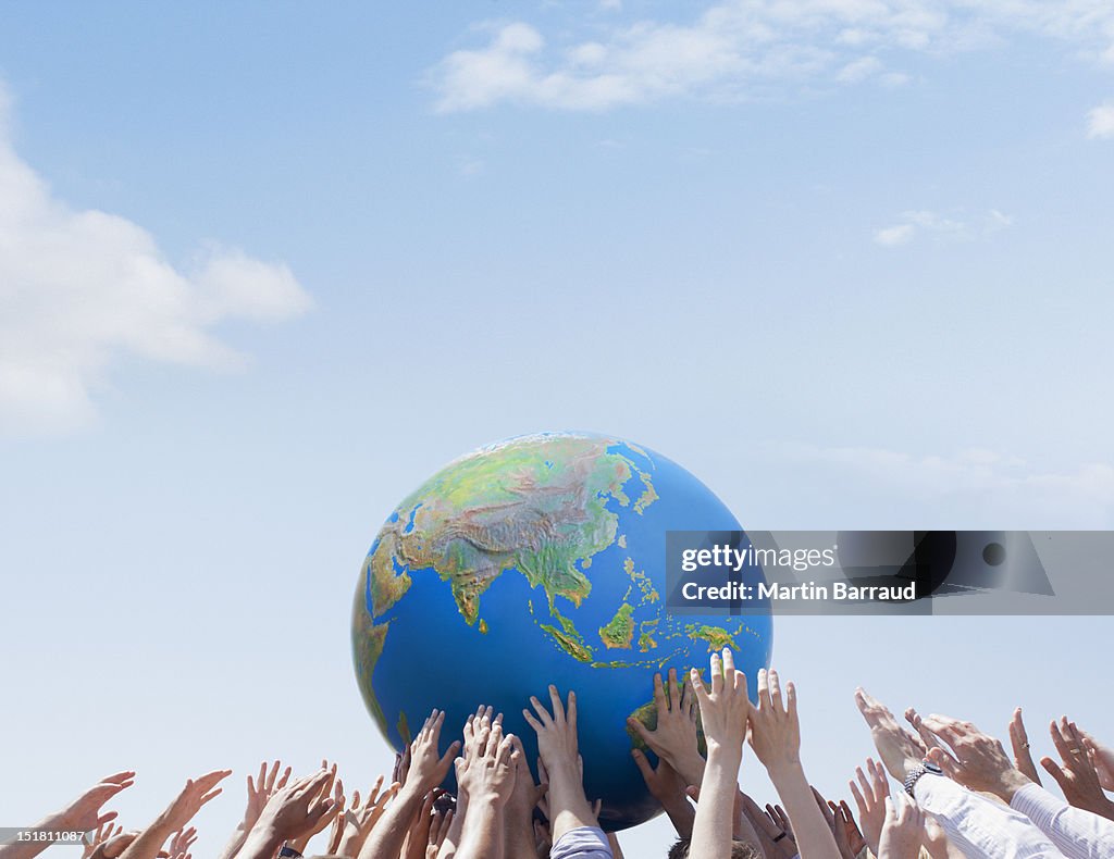 Crowd reaching for globe