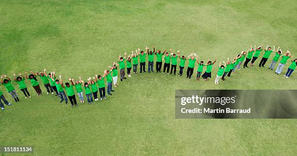 portrait of people in green t-shirts forming wavy line in field - community volunteer 個照片及圖片檔