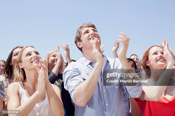 crowd of smiling people clapping and looking up - crowd looking up stock pictures, royalty-free photos & images