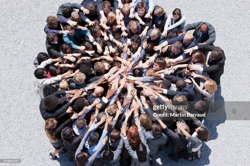 Multidão de pessoas de negócios formando huddle com braços alargada