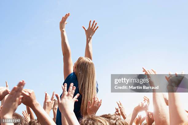 woman with arms raised above crowd - women cheering stock pictures, royalty-free photos & images