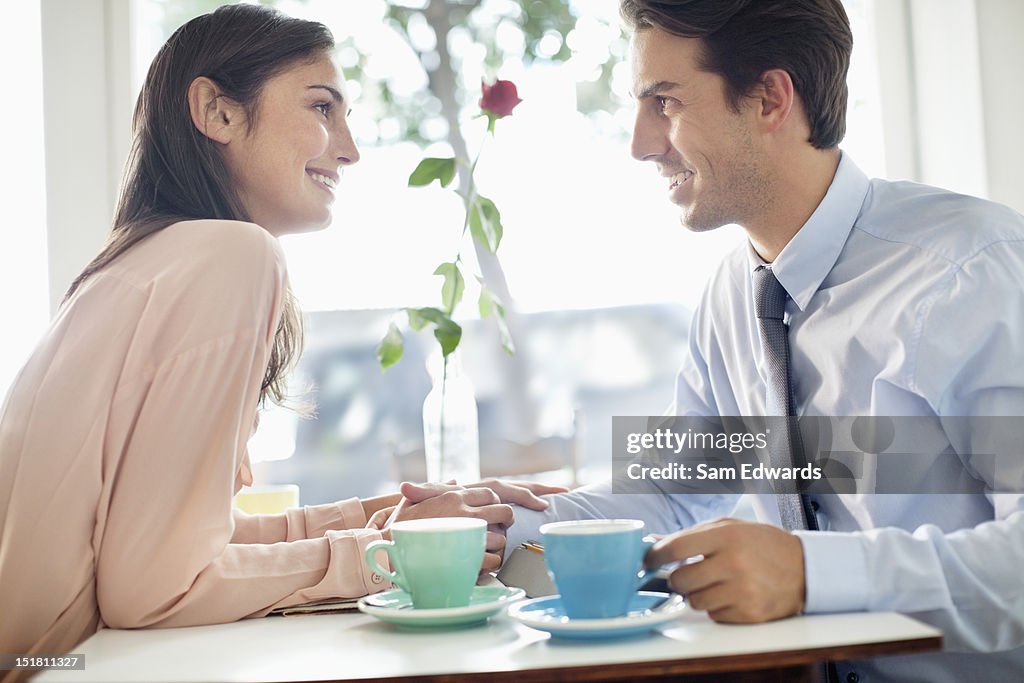 Lächelnd paar Hände halten und Trinken Kaffee im Café