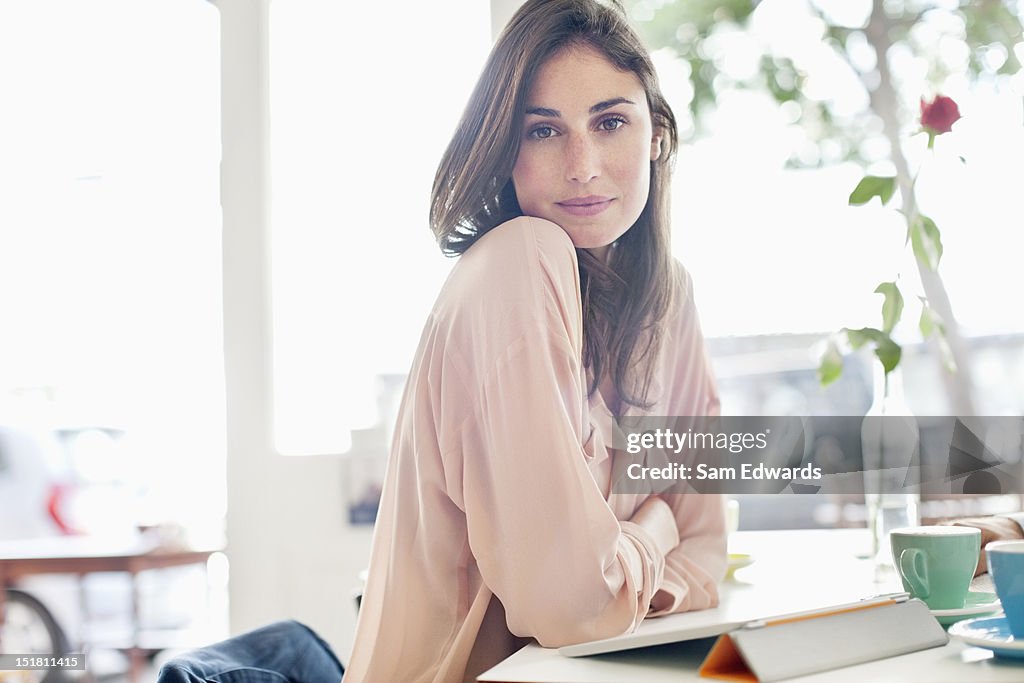 Portrait of confident woman with digital tablet in cafe