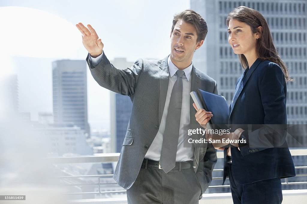 Businessman and businesswoman talking on urban balcony