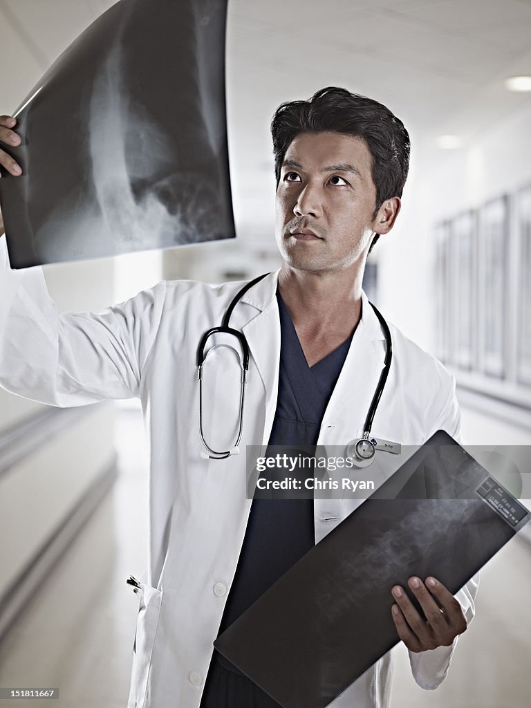 Doctor examining x-rays in hospital corridor