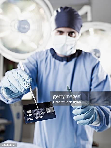 retrato do cirurgião segurando o cartão de crédito em cirurgia - scalpel - fotografias e filmes do acervo
