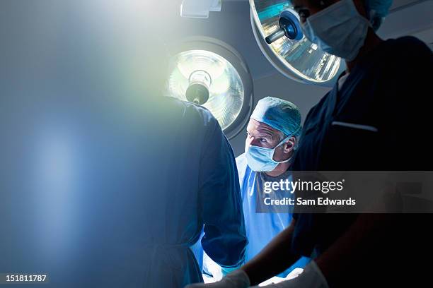 surgeons working in operating room - surgical equipment stockfoto's en -beelden
