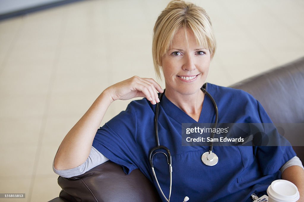 Portrait of smiling nurse drinking coffee