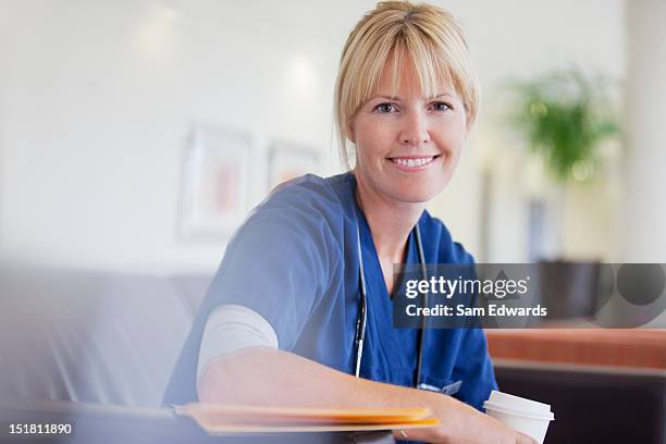 portrait of smiling nurse drinking coffee in hospital - nurse smiling stock pictures, royalty-free photos & images
