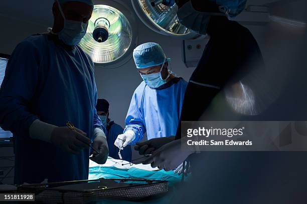 surgeons working in operating room - surgery stock pictures, royalty-free photos & images