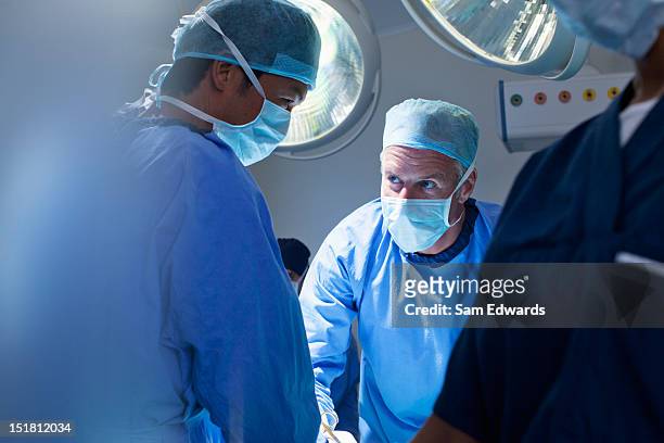 chirurgo al lavoro in sala operatoria - operating room foto e immagini stock