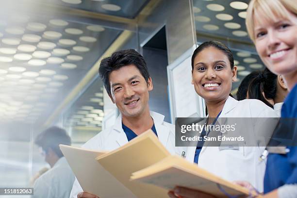 portrait of smiling doctors and nurse with medical records - european best pictures of the day december 3 2012 stockfoto's en -beelden