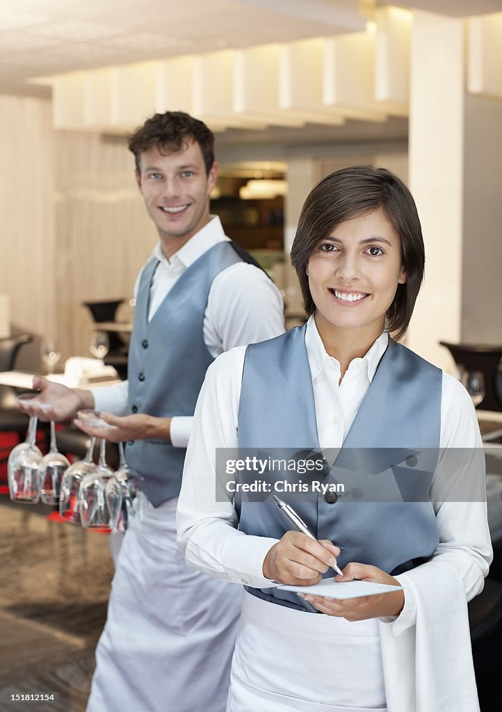 Retrato de la sonriente y camarera camarero en el restaurante