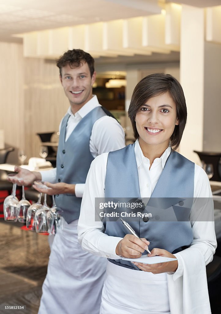 Portrait of smiling waiter and waitress in restaurant
